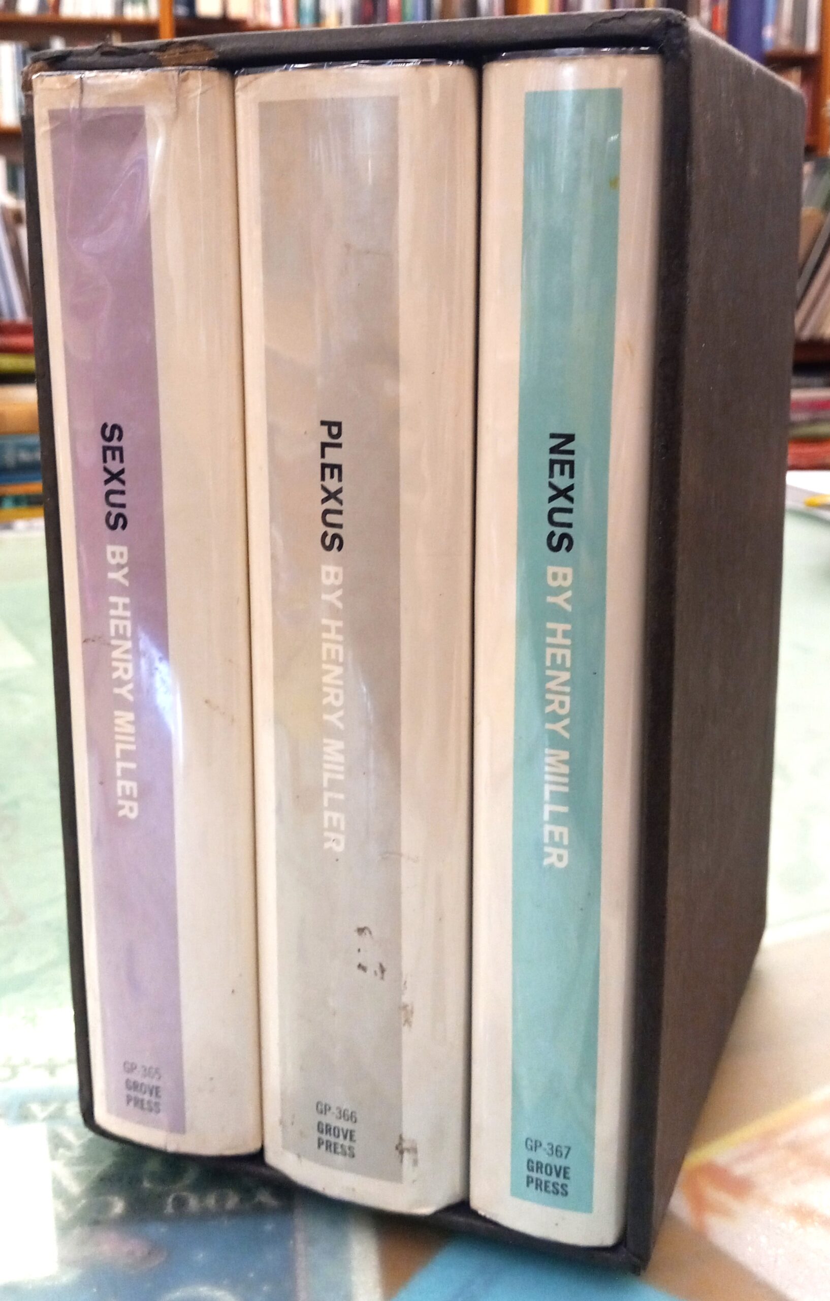 Spines in jackets of all three volumes of The Rosy Crucifixion in slipcase